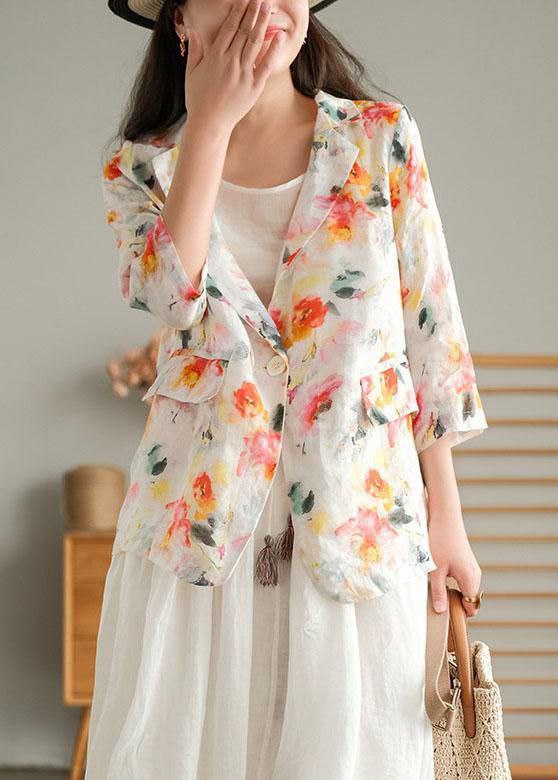 Woman wearing a floral kimono-style jacket over a white dress, standing against a neutral background.