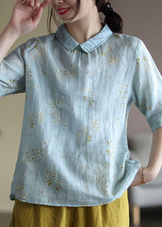Light blue floral blouse worn by a person with a blurred background