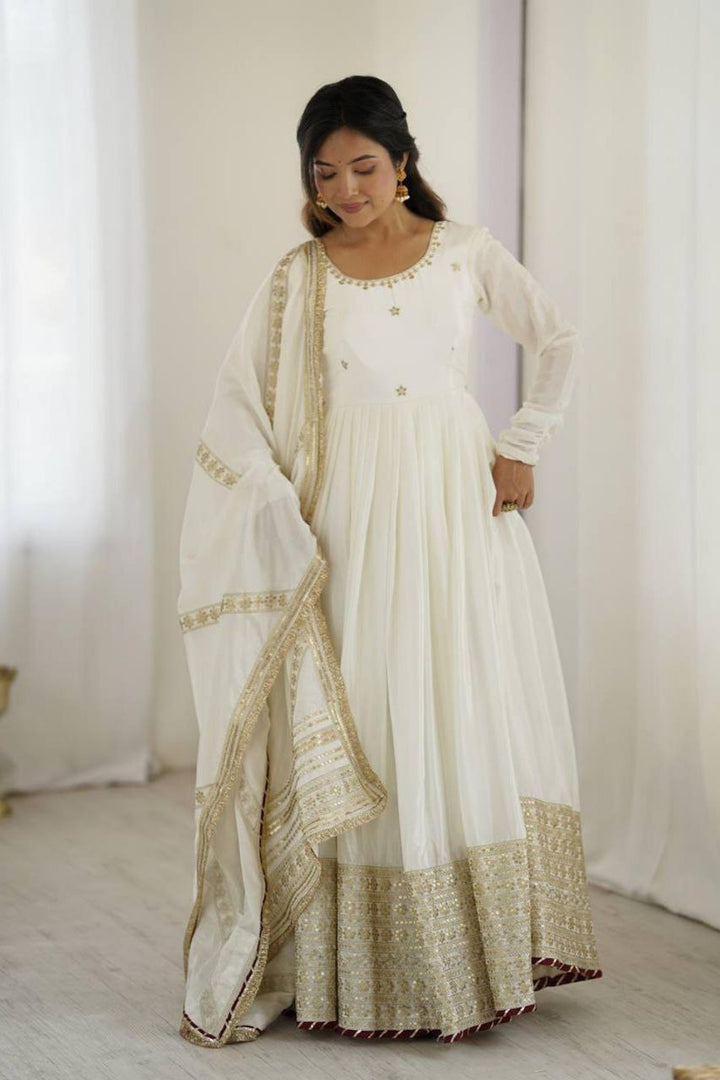 Woman wearing a traditional white and gold outfit with a white background