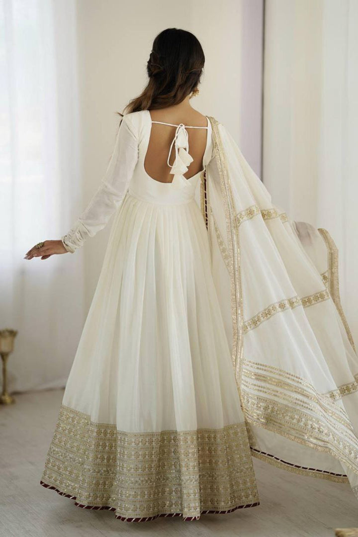 Traditional white ethnic outfit featuring flared silhouette and golden detailing.