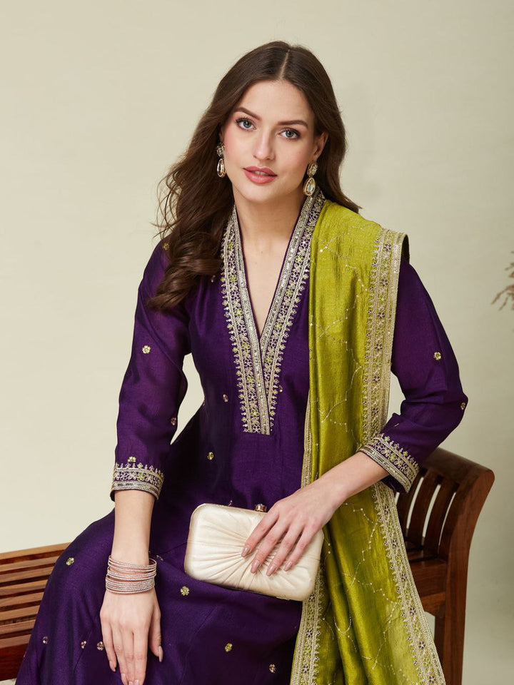 Festive purple Anarkali dress in Roman Silk with golden embroidery and green dupatta.