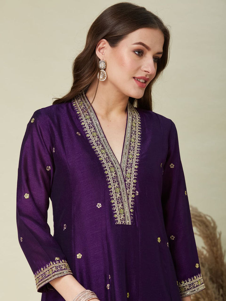 Woman wearing a purple embroidered outfit on a beige background