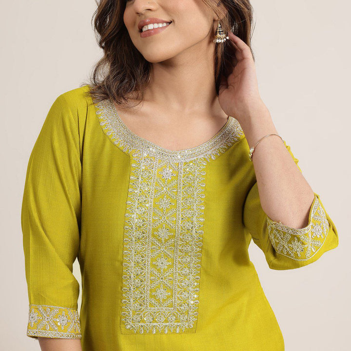 “Detailed close-up of mustard kurta featuring intricate silver embroidery on neckline and sleeves.”