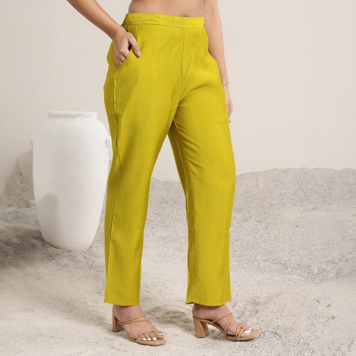 “Mustard Roman Silk straight-fit pants styled with nude heels.”