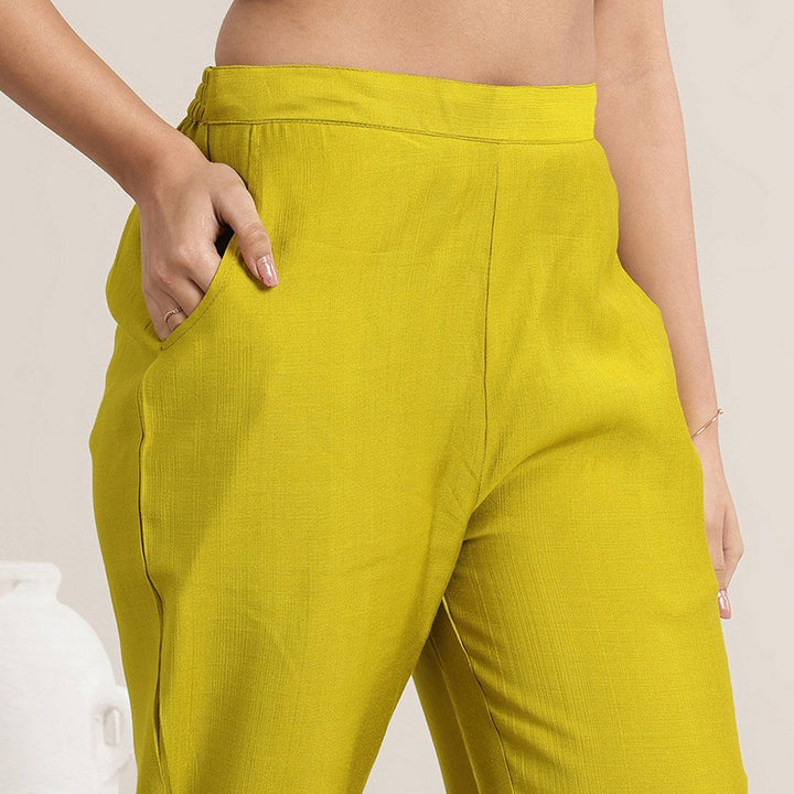 “Close-up of mustard Roman Silk pants showing waistband and side pocket detail.”